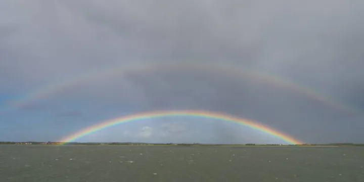 dubbele regenboog op de waddenzee.